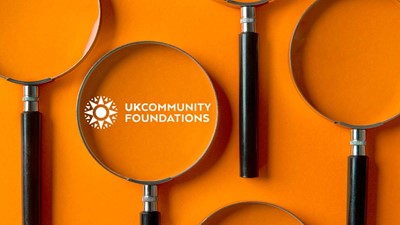 orange surface with 5 magnifying glasses lined up next to each other. In one magnifying glass that is the UKCF logo.