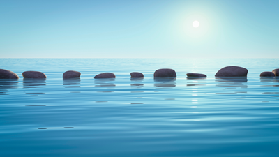 stepping stones across a still body of water in the sunshine